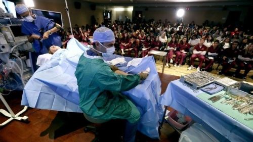 doctor performing surgery in front of class